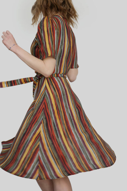 Mulher em vestido midi envoltório listrado multicolorido funky. Estúdio. - Foto, Imagem