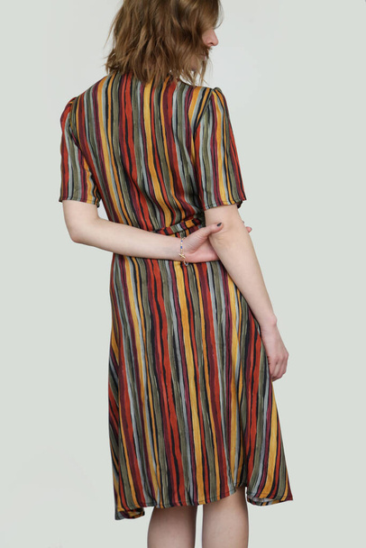 Mujer en funky multicolor rayas envoltura midi vestido. Captura de estudio. - Foto, imagen
