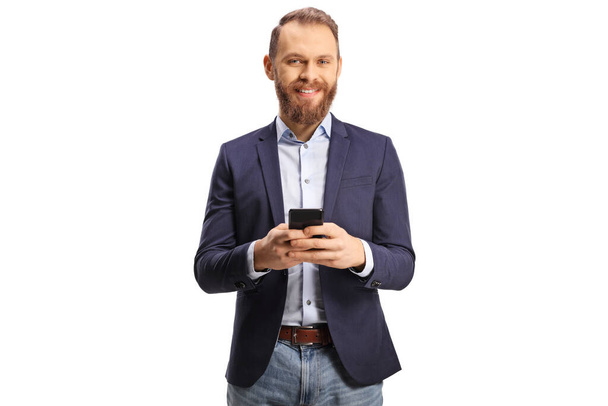 Bearded guy in suit and jeans using a mobile phone and smiling isolated on white background - Foto, imagen