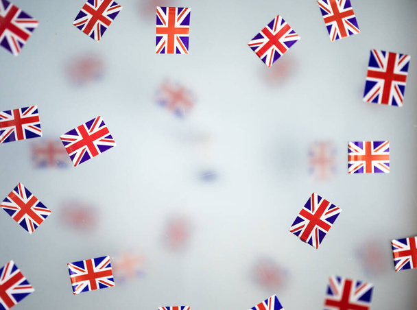 Wielka Brytania, kraj świąt narodowych. Mini flagi na przezroczystym mglistym tle. koncepcja patriotyzmu, dumy i wolności. Platynowy Jubileusz Królowej Elżbiety II. Wysokiej jakości zdjęcie - Zdjęcie, obraz
