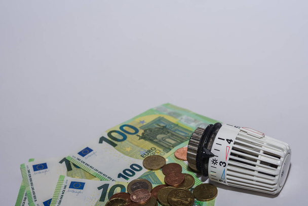 Energieprijzen stijgen en energieverbruik thermostatische regelgever van verwarming met eurobiljetten en -munten onderste aanzicht - Foto, afbeelding