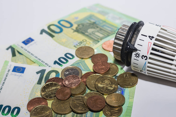 Energieprijzen stijgen en energieverbruik thermostatische regelgever door verwarming met eurobiljetten en -munten macro-view - Foto, afbeelding