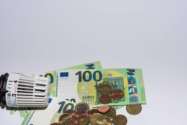 Energieprijzen stijgen en energieverbruik thermostatische regelgever van verwarming met eurobiljetten en munten bovenaanzicht - Foto, afbeelding