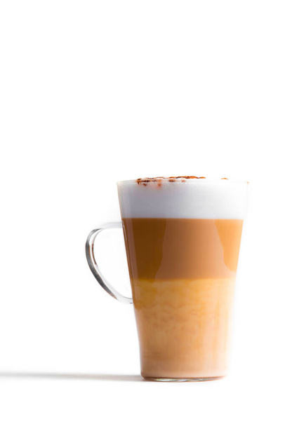 Latte macchiato in a tall glass on a white background. Cafe latte layered with milk in a high drinking glass. Minimalism. copy space - Фото, изображение