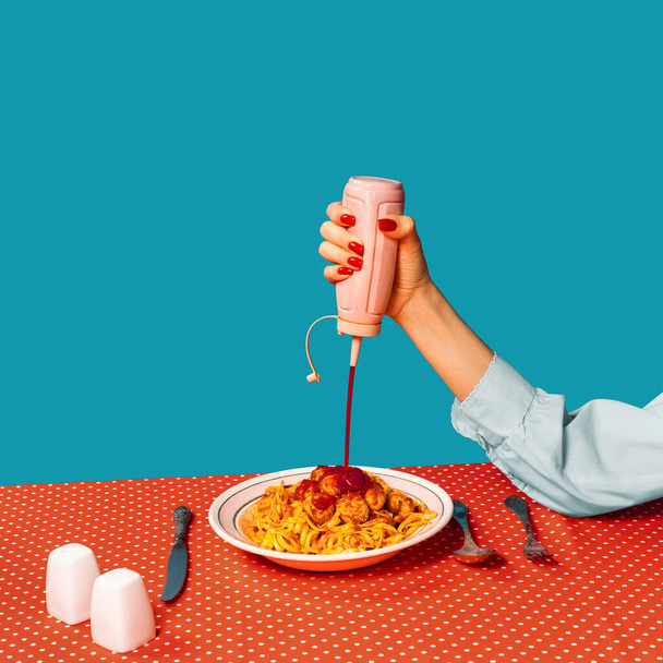 Food pop art photography. Female hands tasting spaghetti with meatballs on plaid tablecloth isolated on bright blue background. Vintage, retro style interior - Fotó, kép