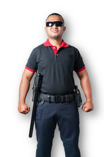 Siyah gözlüklü bir güvenlik görevlisi güçlü bir alarm duruşu ve lastik sopalarla dimdik ayakta duruyor. Beyaz bir arka planda, izole edilmiş, kesilmiş. Güvenlik kavramı - Fotoğraf, Görsel