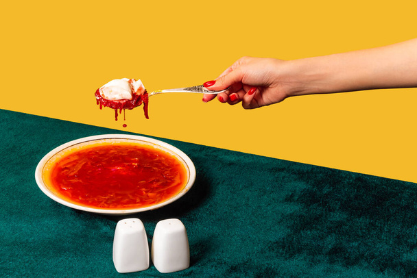 Creative artwork. Female hand with spoon tasting Ukrainian borshch. Vintage, retro style interior. Food pop art photography. - Фото, изображение