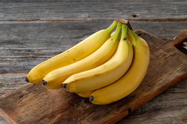 ripe banana on wood background - Foto, afbeelding