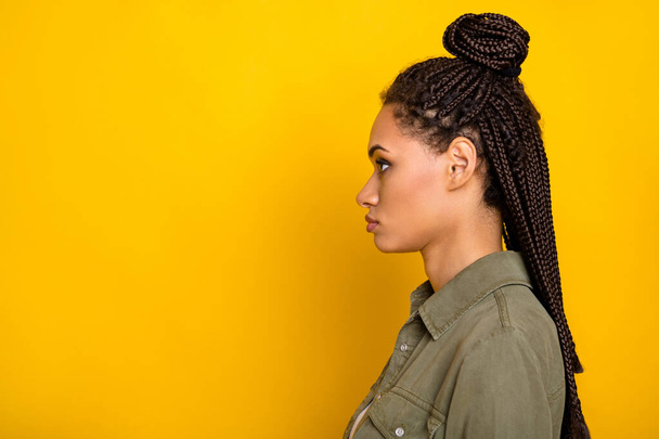 Φωτογραφία πορτρέτο πλευρά προφίλ άποψη της αφρικανικής αμερικανικής γυναίκας κοιτάζοντας κενό χώρο που απομονώνονται σε ζωντανό κίτρινο χρώμα φόντο - Φωτογραφία, εικόνα