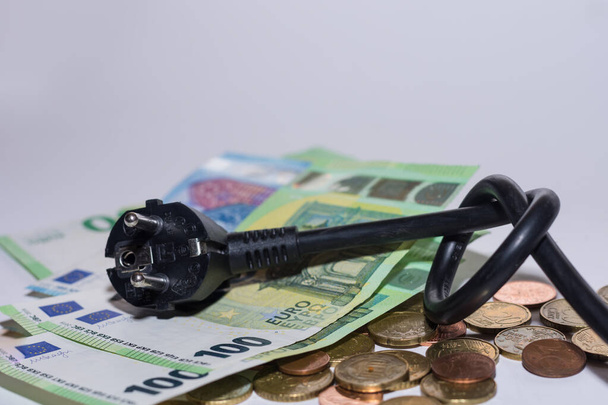 Energy prices increase and energy consumption power cable with knot and money above with gray background - Photo, Image