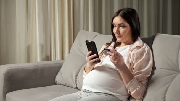 Esmer hamile kadın internet alışverişini telefonla yapıyor. - Video, Çekim