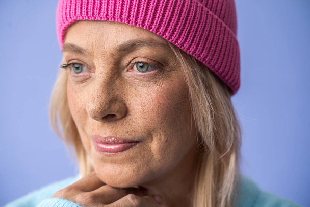 Serious freckled woman wearing hat looking away with calm expression - Photo, image