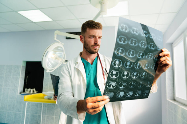 young doctor looking at ct, mri scan at hospital to make diagnosis - Фото, изображение