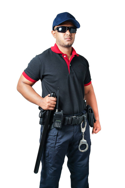 Φρουροί ασφαλείας με μαύρα γυαλιά και καπέλα στέκονται κρατώντας μια λαστιχένια μπαγκέτα και χειροπέδες σε μια τακτική ζώνη. σε ένα απομονωμένο λευκό φόντο Εξάλειψη της έννοιας της ασφάλειας - Φωτογραφία, εικόνα