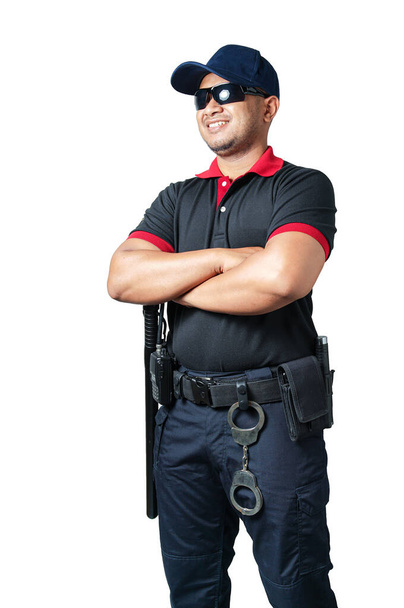 警備員は黒い眼鏡をかけ、戦術的なベルトに腕を交差させ、ゴム製のバトンと手錠をかけて帽子をかぶっている。隔離された白い背景にセキュリティの概念を排除する - 写真・画像