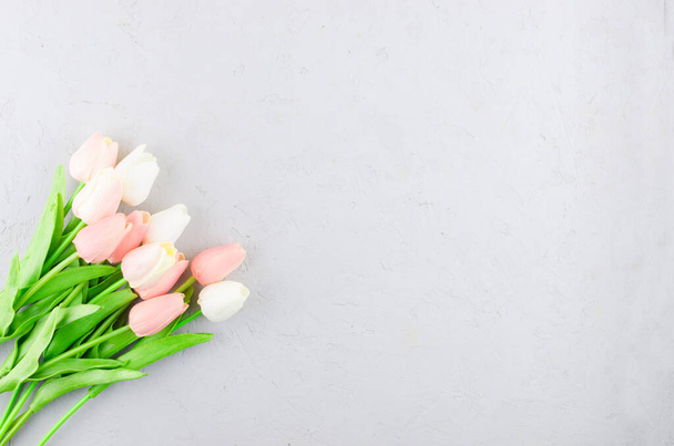 Top view on Beautiful pastel tulips bouquet on grey concrete background, Spring or holiday concept, Easter or Valentine's day, birthday. Copy space, template mockup greeting card,  place for text,  - Foto, Bild