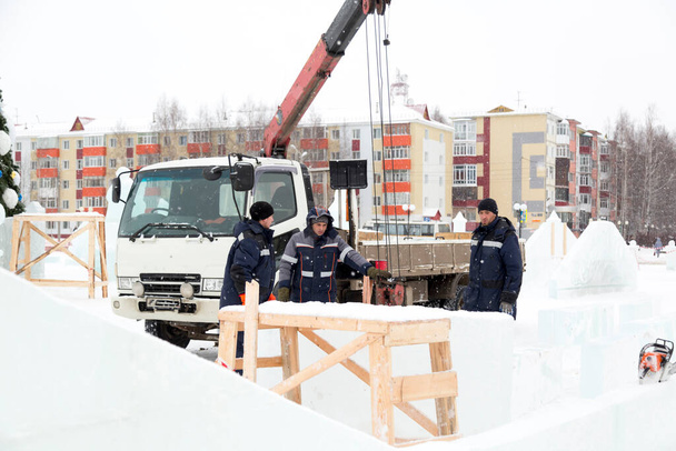 Trabalhadores perto do guindaste hidráulico na construção da cidade de gelo
 - Foto, Imagem