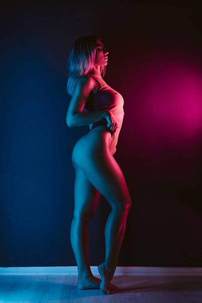 beautiful girl in bodysuit in neon lighting - Foto, Imagen