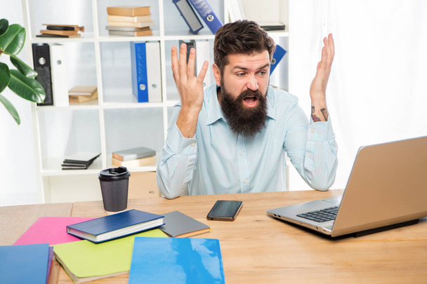 Angry businessman working on laptop at office desk, work - Photo, image