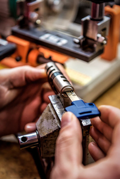 professional locksmith is testing door lock cylinder with key - Photo, Image
