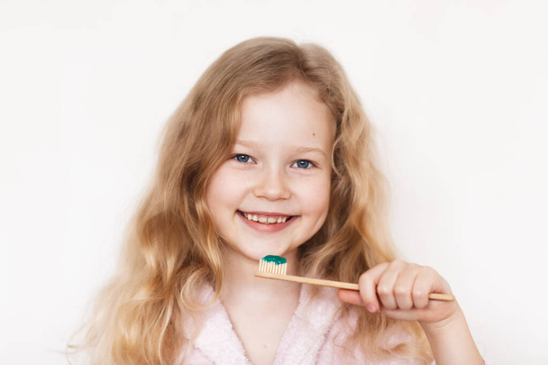A girl on a white background brushes her teeth - Φωτογραφία, εικόνα