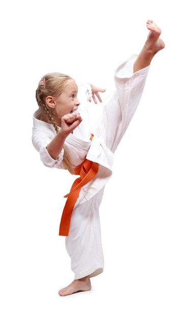 Циркулярный удар ногой делает sportwoman в karategi
 - Фото, изображение