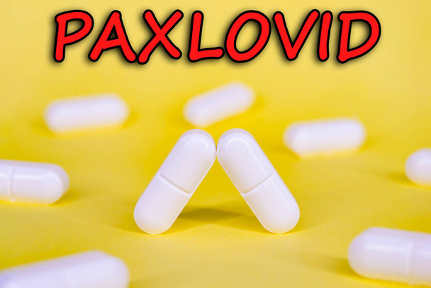 Paxlovid. Antiviral against Covid-19 (Coronavirus). Revolutionary pills for Covid. Background with pills on yellow background. Horizontal photography. Design with text. - Photo, Image