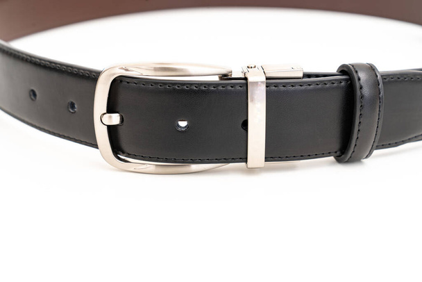 parte del cinturón de cuero negro y marrón de doble cara en un blanco. - Foto, Imagen