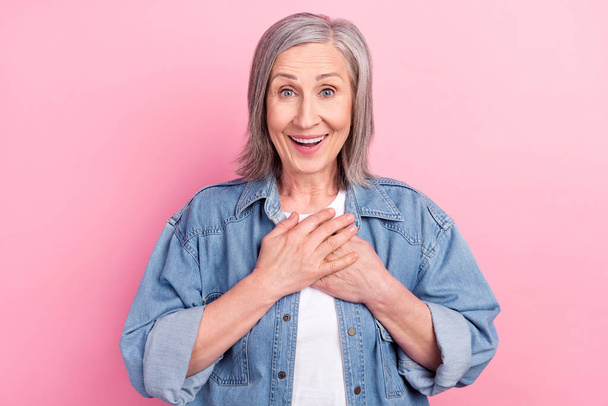 Photo of thankful old woman happy mood hold hands chest heart isolated on pastel pink color background - Valokuva, kuva