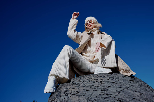 žena sedí na kameni příroda modrá obloha v klobouku životní styl - Fotografie, Obrázek