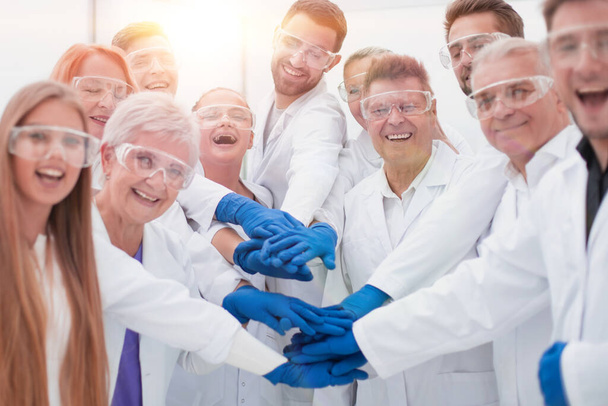 group of medical lab employees joining their palms together. - Zdjęcie, obraz
