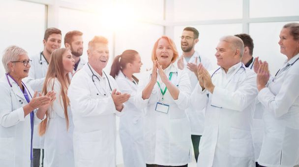 group of diverse smiling doctors applauding together. - 写真・画像