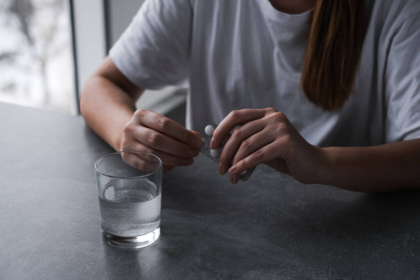sick woman drinking a pill with a glass of water - Zdjęcie, obraz