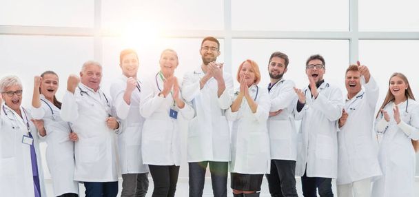 tight-knit group of medical center doctors applauding together. - Фото, изображение