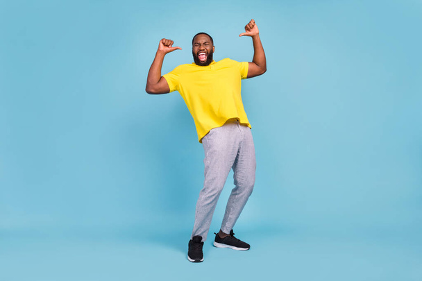 Photo of sweet excited dark skin guy dressed yellow t-shirt smiling pointing fingers himself isolated blue color background - Valokuva, kuva