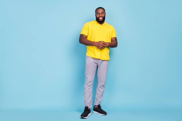 Photo of charming cute dark skin man wear yellow t-shirt standing smiling isolated blue color background - Foto, afbeelding