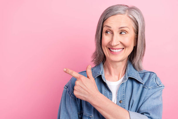 Photo of old lovely happy lady point finger empty space comment sale news isolated on pink color background - Foto, immagini