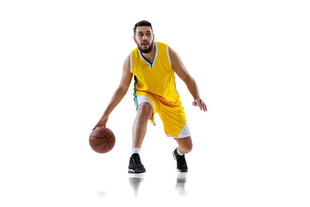 白いスタジオの背景に隔離されたプロのバスケットボール選手のトレーニングの完全な長さの肖像画。スポーツ、運動、活動、運動の概念. - 写真・画像