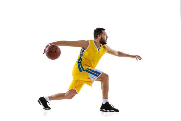 Studio shot of professional basketball player training isolated on white studio background. Sport, motion, activity, movement concepts. - Photo, Image