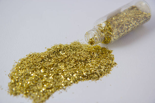 Golden confetti in a transparent bottle - Фото, зображення