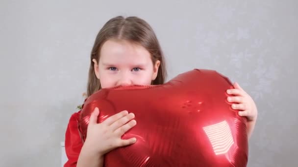 Pretty cute girl holding heart shaped crane balloons on valentines day. - Video