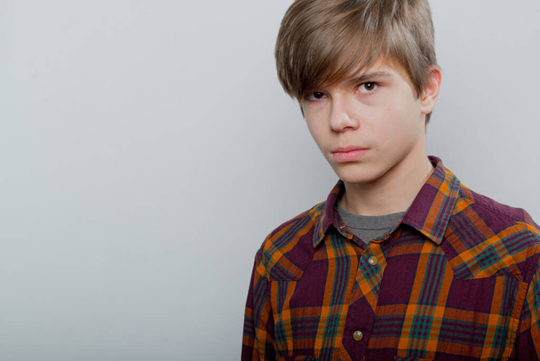 Emotional portrait of a teenager in a plaid shirt - Zdjęcie, obraz