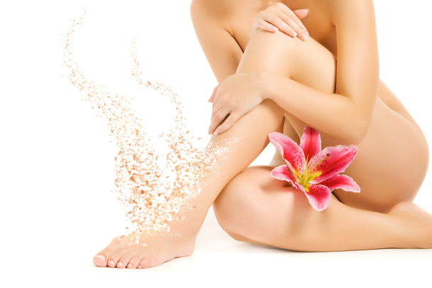 Γυναικεία πόδια με ροζ κρίνος που απομονώνονται σε λευκό φόντο - Φωτογραφία, εικόνα