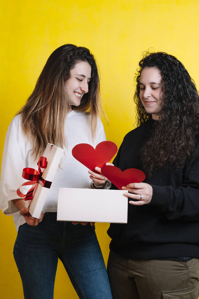Couple of two girls giving each other gifts for Valentine's Day. - Zdjęcie, obraz