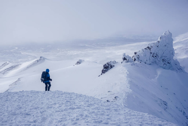 Wandelaar bij de Avachinsky Pass en vulkanen in Kamchatka in de winter - Foto, afbeelding