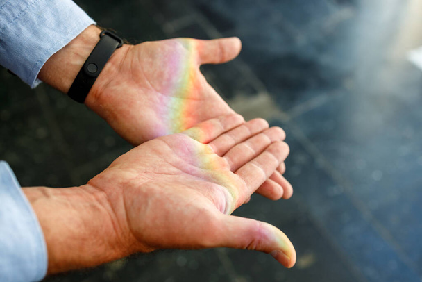радуга на открытых ладонях, фон размыт. радуга в мужских руках - Фото, изображение