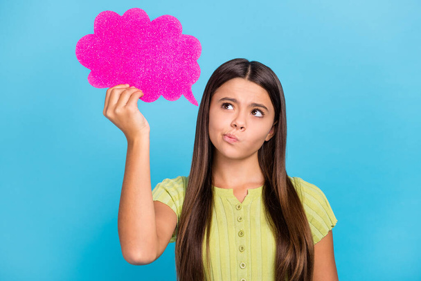Photo of clever uncertain puzzled lady hold pink bubble look up wear green top isolated blue color background - Foto, Bild