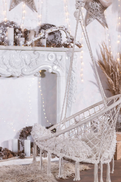 Εορταστική Πρωτοχρονιάτικο λευκό εσωτερικό με ψάθινη καρέκλα και τζάκι - Φωτογραφία, εικόνα