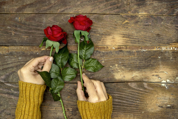 mujer vistiendo suéter de invierno y sosteniendo flores de rosas rojas para el día de San Valentín o de las mujeres, día de la madre - Foto, imagen