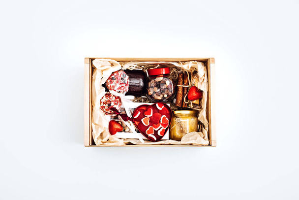 Valentine Day gift box with sweets, candy, vegetarian healthy organic food . Valentines Day flat lay with gift box with yummy heart shape sweets on white background - Photo, image